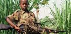 An African boy enjoying a hold on to the AK47 gun.